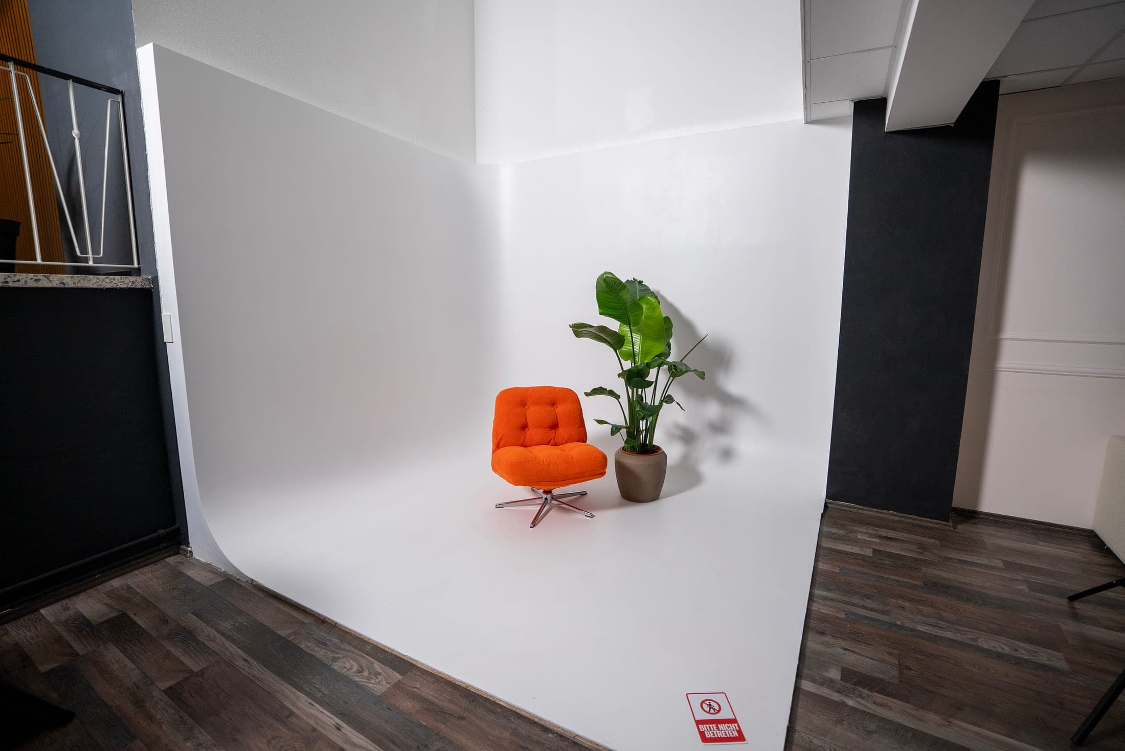 Kompakte weiße Hohlkehle mit orangefarbenem Sessel und Pflanze